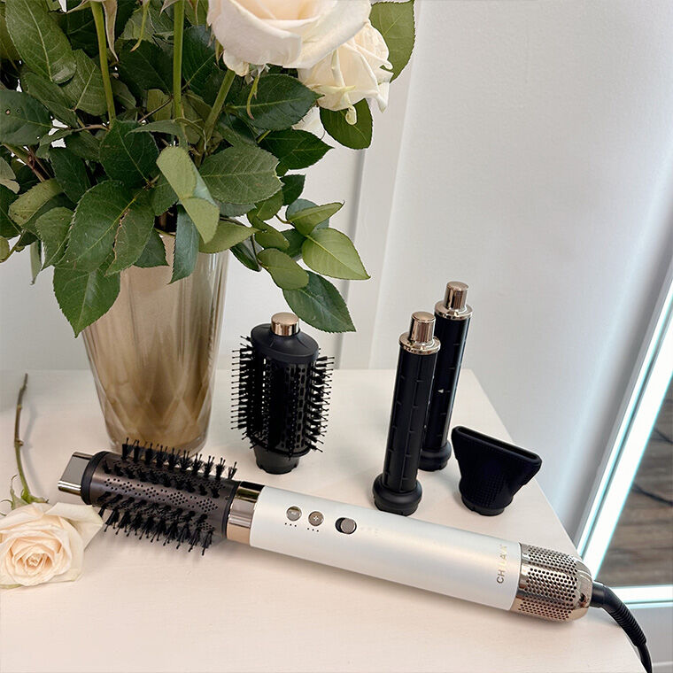 Lava Air Glam Multi Styler laying on a countertop next to the multi-styling attachments