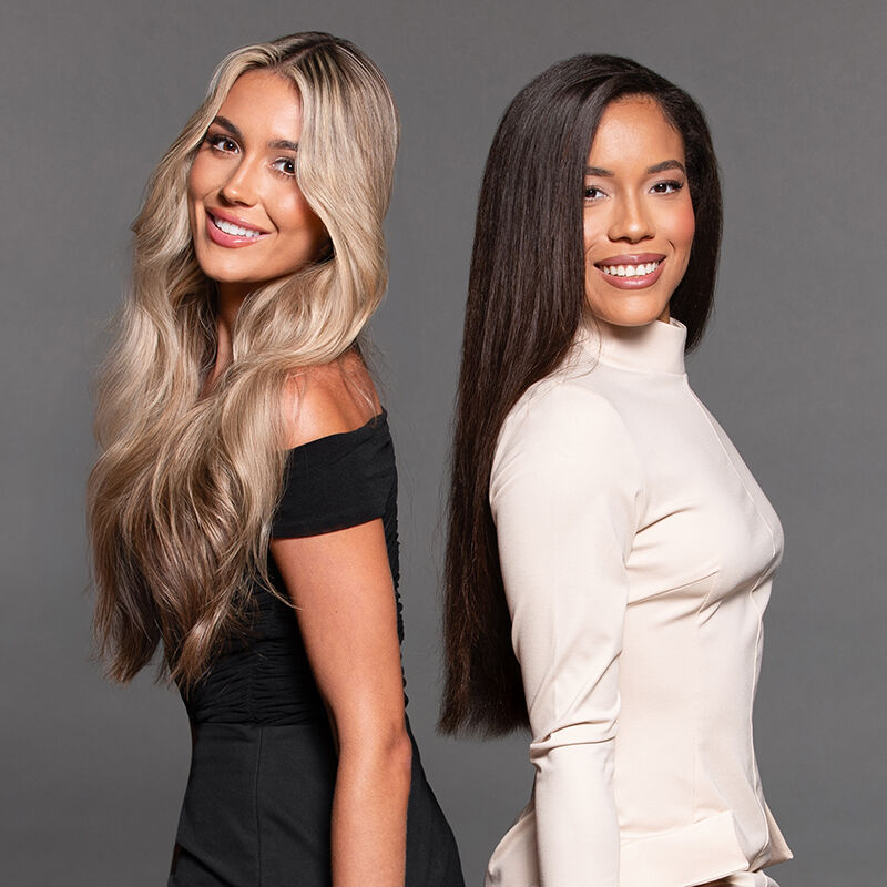 Two models standing back to back as they smile into the camera